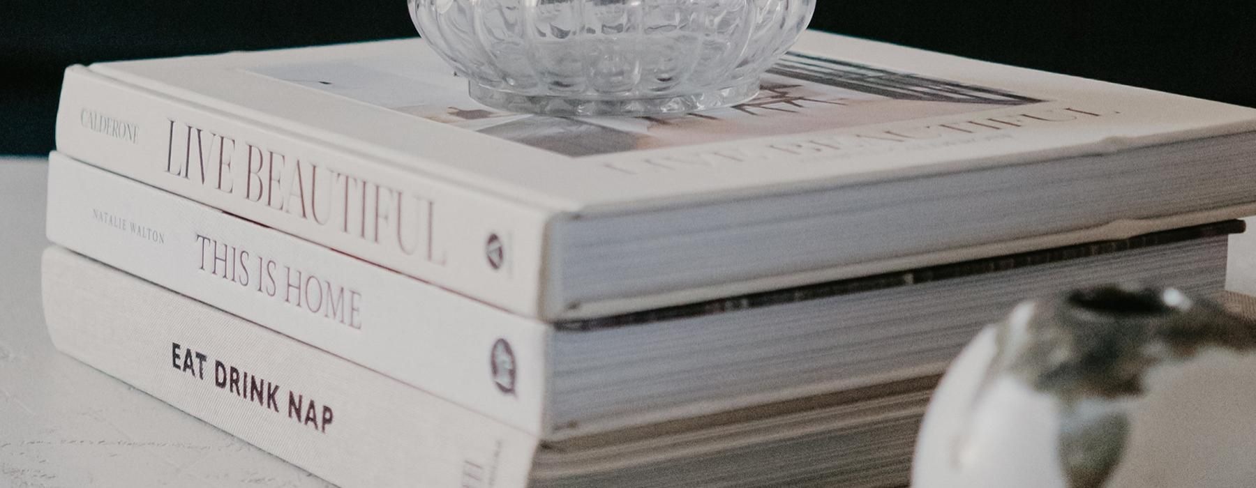 a stack of books and vases on a table top